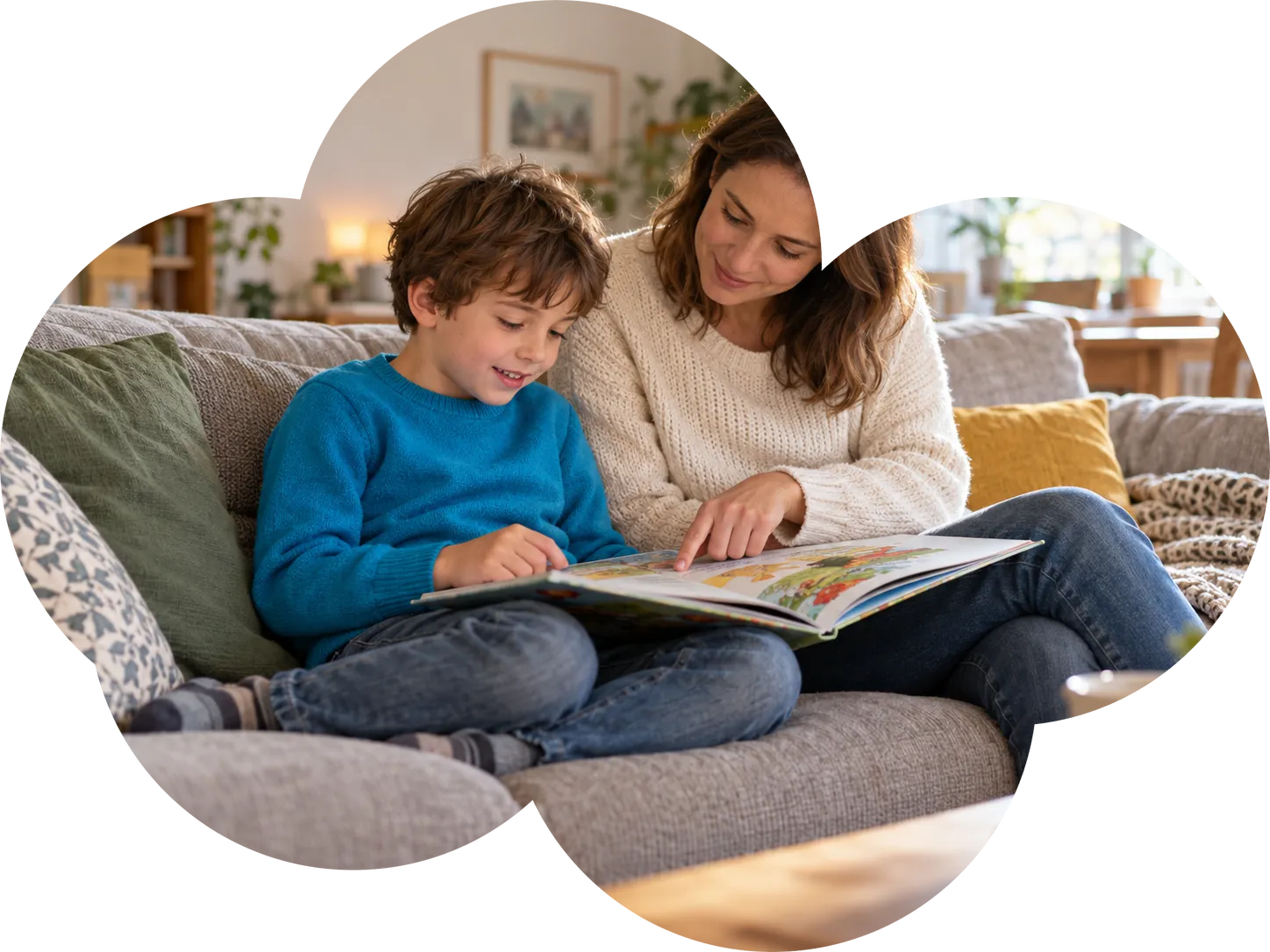 Un niño lee un libro ilustrado en el sofá mientras su madre le señala la línea